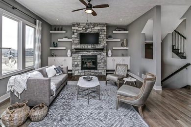 Inspiration for a medium sized traditional open plan living room in Omaha with grey walls, medium hardwood flooring, a standard fireplace and a stone fireplace surround.