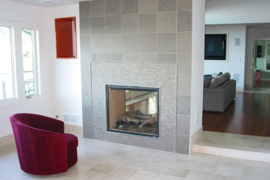Imagen de salón abierto clásico de tamaño medio sin televisor con paredes blancas y chimenea de doble cara