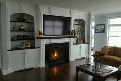 ポートランド(メイン)にある低価格の広いトラディショナルスタイルのおしゃれなLDK (濃色無垢フローリング、標準型暖炉、壁掛け型テレビ、グレーの壁、タイルの暖炉まわり、茶色い床) の写真