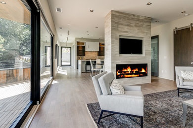 Design ideas for a large contemporary formal open plan living room in Other with white walls, light hardwood flooring, a two-sided fireplace, a stone fireplace surround and a built-in media unit.