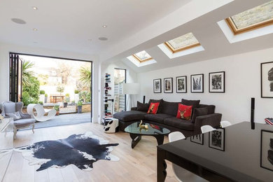 Cette photo montre un salon chic avec un mur blanc, parquet clair et aucune cheminée.