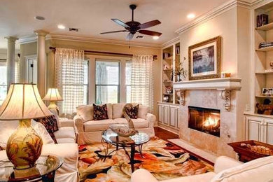 Example of a large classic formal and open concept medium tone wood floor and brown floor living room design in New Orleans with beige walls, a standard fireplace and a tile fireplace