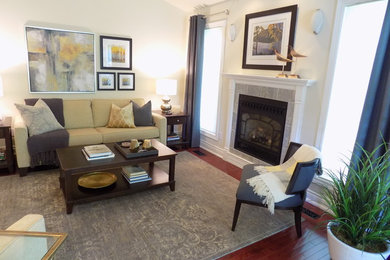 Example of a mid-sized transitional enclosed medium tone wood floor living room design in Toronto with white walls, a standard fireplace, a stone fireplace and no tv