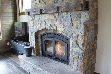 ソルトレイクシティにある高級な広いラスティックスタイルのおしゃれなリビング (白い壁、濃色無垢フローリング、標準型暖炉、石材の暖炉まわり) の写真