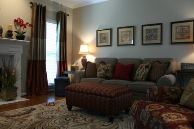 Mittelgroßes Klassisches Wohnzimmer mit beiger Wandfarbe, braunem Holzboden, Kamin, Kaminumrandung aus Stein und freistehendem TV in Atlanta
