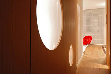Immagine di un piccolo soggiorno bohémian aperto con libreria, pareti bianche, pavimento in legno massello medio e TV autoportante