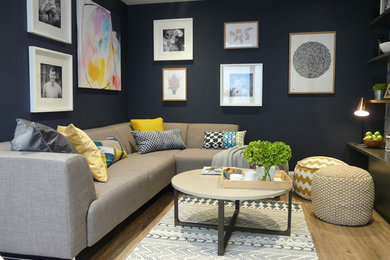 Esempio di un piccolo soggiorno contemporaneo aperto con sala formale, pareti blu, pavimento in laminato, TV autoportante e pavimento marrone