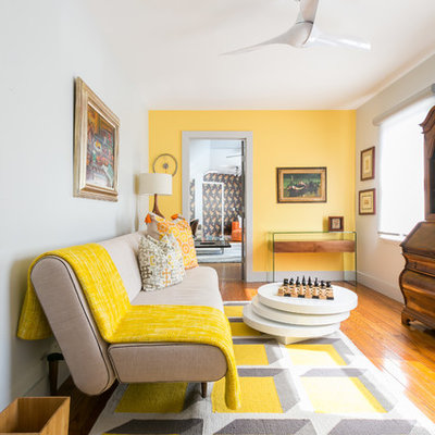 Mid-sized eclectic formal and open concept medium tone wood floor and brown floor living room photo in Charleston with yellow walls, no fireplace and no tv