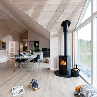 Inspiration for a mid-sized scandinavian formal and open concept light wood floor living room remodel in Aarhus with beige walls and a wood stove