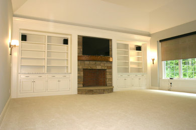 Example of a mid-sized classic enclosed carpeted living room design in Cleveland with white walls, a standard fireplace, a stone fireplace and a wall-mounted tv