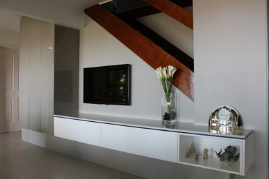 Imagen de salón abierto contemporáneo de tamaño medio sin chimenea con suelo de baldosas de cerámica y pared multimedia