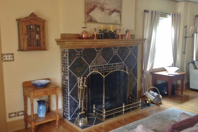 ニューヨークにある低価格の小さなトランジショナルスタイルのおしゃれなLDK (標準型暖炉、タイルの暖炉まわり、黄色い壁、淡色無垢フローリング) の写真