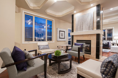 Großes, Repräsentatives, Fernseherloses, Offenes Klassisches Wohnzimmer mit beiger Wandfarbe, braunem Holzboden, Kamin und gefliester Kaminumrandung in Calgary