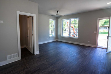 Стильный дизайн: открытая гостиная комната в стиле кантри с серыми стенами, полом из ламината и коричневым полом - последний тренд