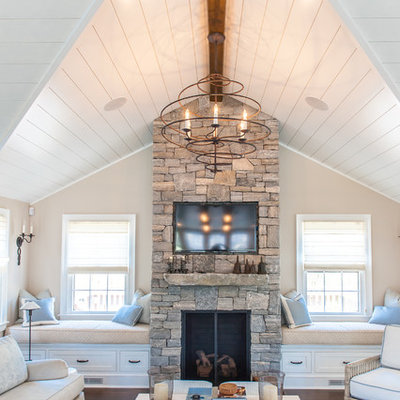 Example of a beach style formal dark wood floor living room design in Boston with beige walls, a standard fireplace, a wall-mounted tv and a stone fireplace