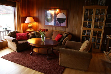 Diseño de salón abierto clásico de tamaño medio con paredes marrones, suelo de madera en tonos medios, chimenea de esquina, marco de chimenea de piedra y televisor independiente