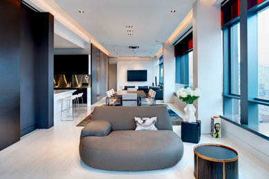 Exempel på ett mellanstort modernt allrum med öppen planlösning, med grå väggar, ljust trägolv, en dold TV och beiget golv
