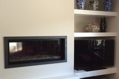 Modernes Wohnzimmer mit braunem Holzboden, Gaskamin und freistehendem TV in San Francisco
