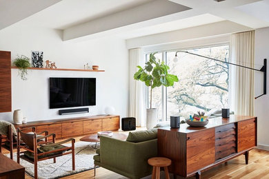 Offenes, Mittelgroßes, Repräsentatives Mid-Century Wohnzimmer ohne Kamin mit weißer Wandfarbe, braunem Holzboden, TV-Wand und braunem Boden in Seattle