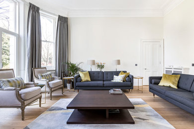 Imagen de salón clásico renovado con paredes blancas, suelo de madera en tonos medios y suelo marrón