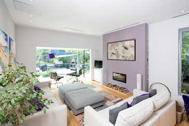 This is an example of a medium sized modern enclosed living room in London with a ribbon fireplace.