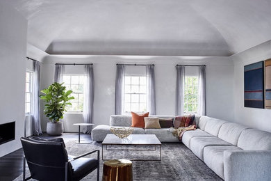 Стильный дизайн: гостиная комната в современном стиле с серыми стенами, темным паркетным полом, стандартным камином и фасадом камина из бетона - последний тренд