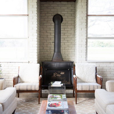 Small country formal living room photo in New Orleans with white walls and a wood stove