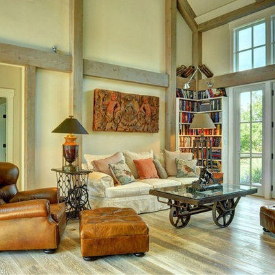 Example of a large country open concept light wood floor living room library design in Burlington with beige walls
