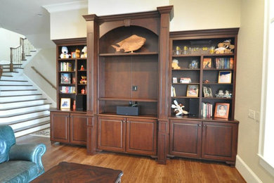 Diseño de salón cerrado tradicional de tamaño medio sin chimenea con paredes beige, suelo de madera en tonos medios y suelo marrón