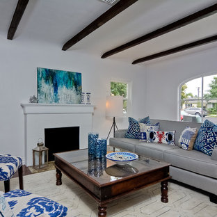 Example of a small southwest formal and open concept medium tone wood floor living room design in San Diego with white walls, a standard fireplace, a plaster fireplace and no tv