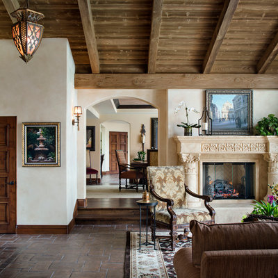 Living room - large mediterranean formal and open concept terra-cotta tile and brown floor living room idea in San Diego with beige walls, a stone fireplace, no tv and a standard fireplace