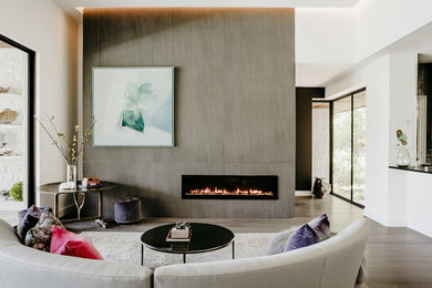 Example of a mid-sized trendy open concept light wood floor and gray floor living room design in Austin with white walls, a ribbon fireplace and a tile fireplace