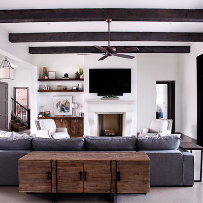 Example of a mid-sized transitional formal and open concept gray floor and concrete floor living room design in Austin with white walls, a standard fireplace, a wall-mounted tv and a plaster fireplace