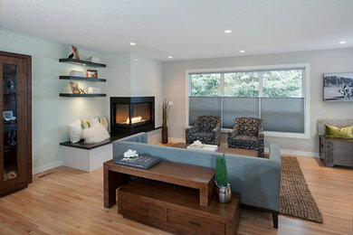 Mid-sized trendy open concept light wood floor living room photo in Calgary with gray walls, a two-sided fireplace and a metal fireplace