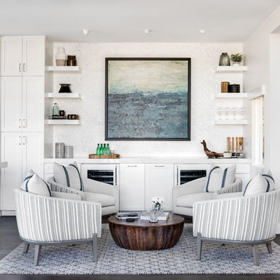 Inspiration for a mid-sized coastal open concept medium tone wood floor and brown floor living room remodel in Los Angeles with a bar, white walls, a standard fireplace and a stone fireplace