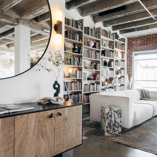 Mittelgroßes Industrial Wohnzimmer ohne Kamin, im Loft-Stil mit weißer Wandfarbe, Betonboden, verstecktem TV, grauem Boden, freigelegten Dachbalken und Ziegelwänden in Sonstige