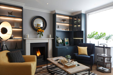 Photo of a small contemporary living room in London with medium hardwood flooring, a standard fireplace and brown floors.