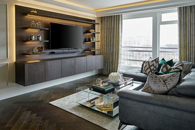 Ejemplo de salón para visitas abierto de tamaño medio con paredes grises, suelo de madera oscura, televisor colgado en la pared y suelo marrón