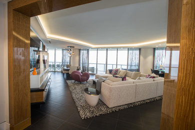 Large trendy open concept porcelain tile and brown floor living room photo in Miami with white walls, no fireplace and a wall-mounted tv