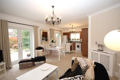 Photo of a medium sized contemporary open plan living room in Kent with beige walls, carpet, a hanging fireplace and beige floors.