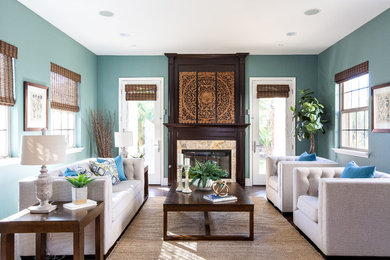 サンディエゴにあるトランジショナルスタイルのおしゃれなリビング (青い壁、濃色無垢フローリング、標準型暖炉、茶色い床、石材の暖炉まわり) の写真