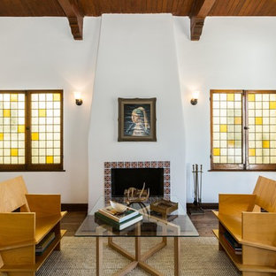 This is an example of a mediterranean formal living room in Los Angeles with white walls, medium hardwood flooring and a standard fireplace.