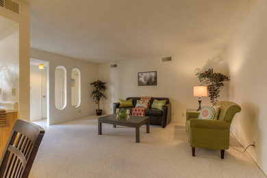 Modelo de salón para visitas abierto clásico renovado de tamaño medio sin chimenea con paredes amarillas y moqueta