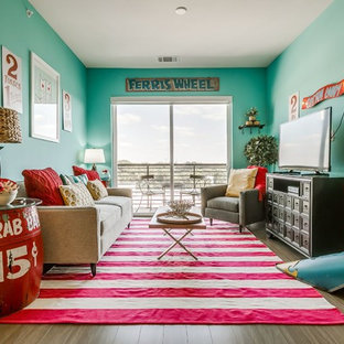 Immagine di un soggiorno boho chic con pareti verdi, pavimento in legno massello medio, TV autoportante e pavimento marrone
