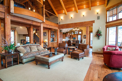 Large mountain style open concept medium tone wood floor living room photo in Denver with beige walls