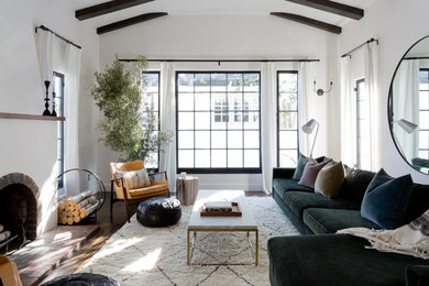 Exempel på ett klassiskt vardagsrum, med vita väggar, mörkt trägolv, en standard öppen spis och brunt golv