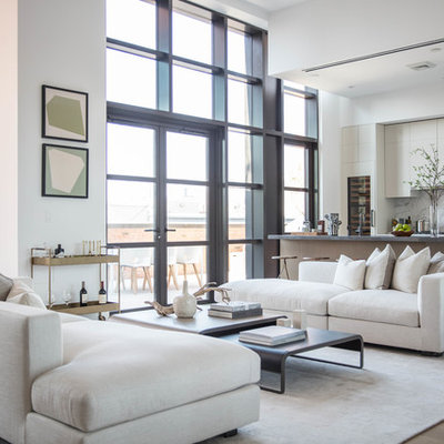 Trendy open concept light wood floor living room photo in New York with white walls and a bar