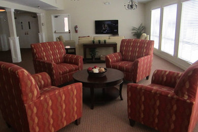 Modelo de salón tradicional con paredes beige, moqueta y televisor independiente