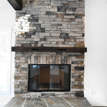 Stone and Reclaimed Wood Mantle Fireplace of Ranch 30 - Mid-Century Modern Count