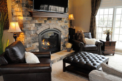 Example of a large mountain style formal and enclosed carpeted and beige floor living room design in Cleveland with beige walls, a standard fireplace, a wall-mounted tv and a stone fireplace